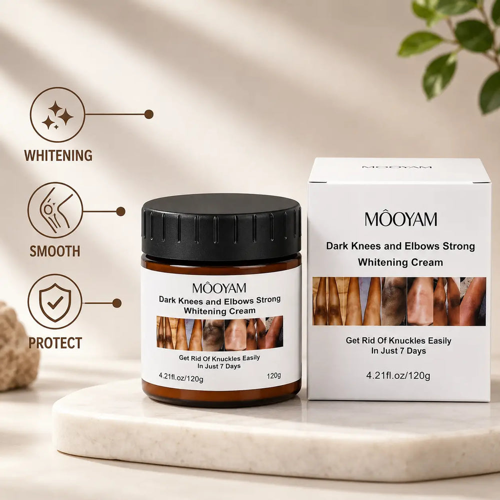 MOOYAM Dark Knees and Elbows Strong Whitening Cream in an amber jar with a black cap, displayed beside its white product box on a marble slab.